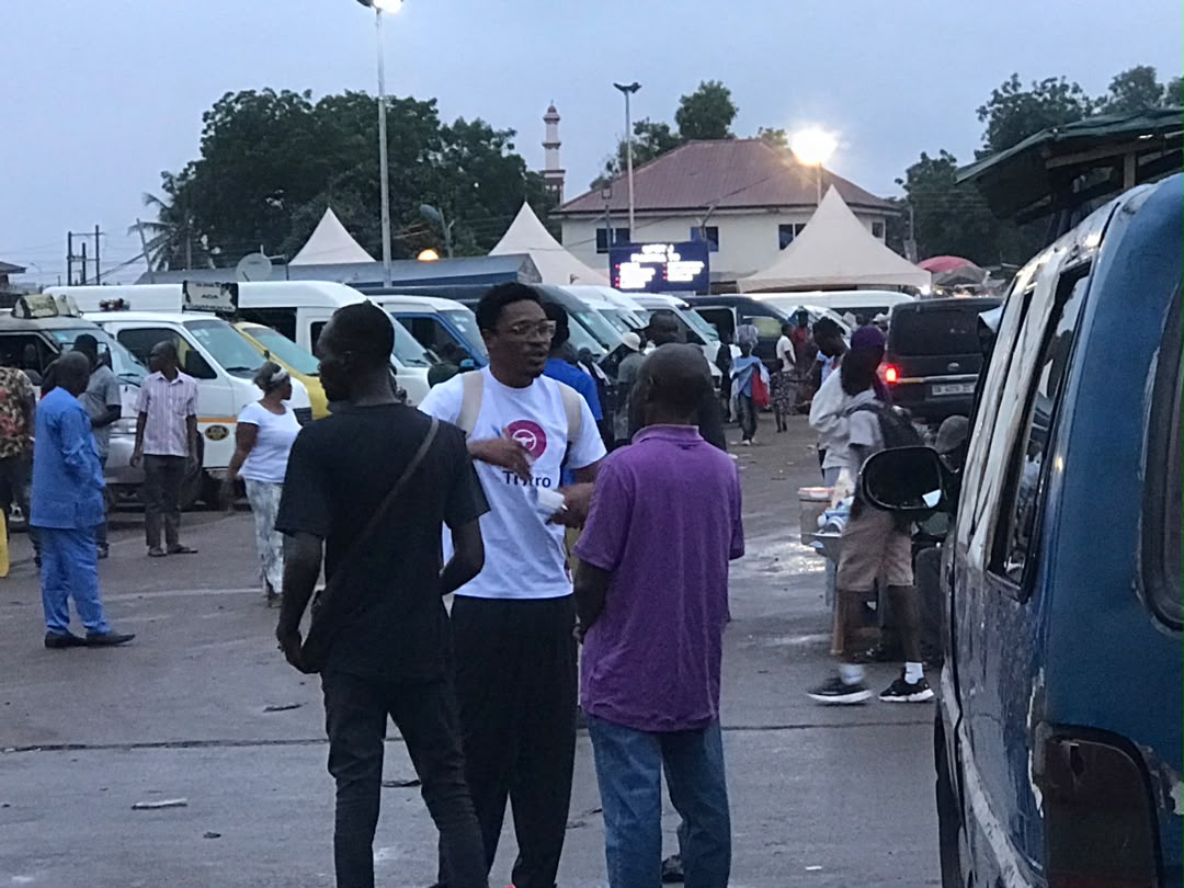 Team sitting with a driver reviewing the app at Kaneshie
