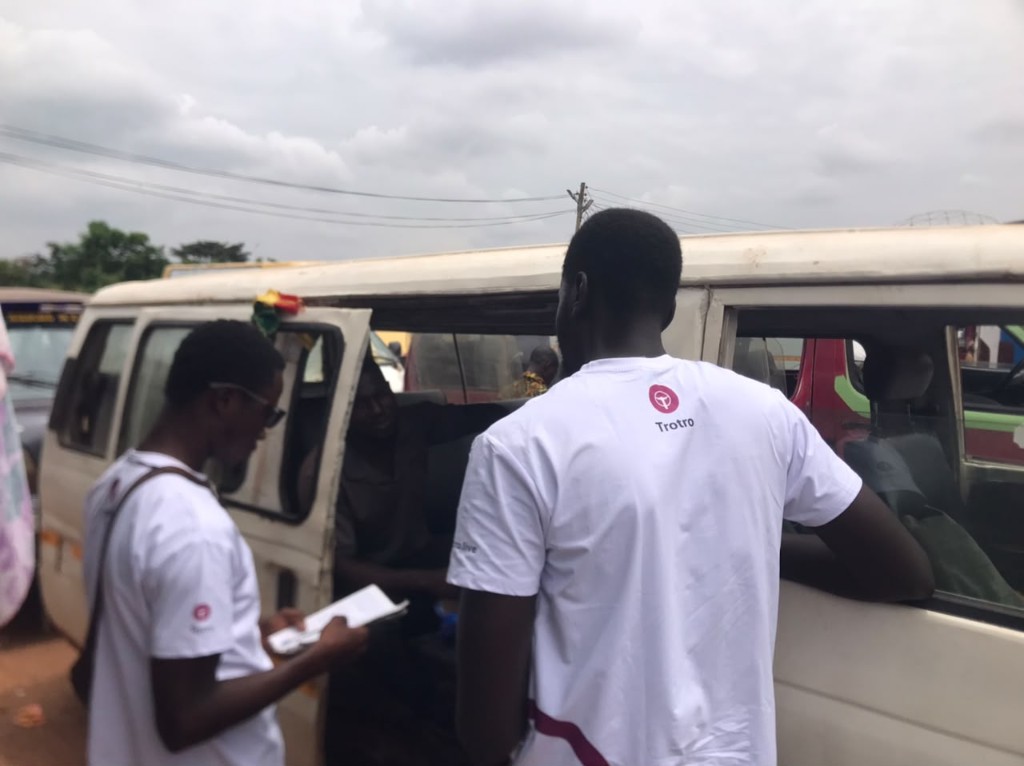 Team member helping a woman pay her fare digitally