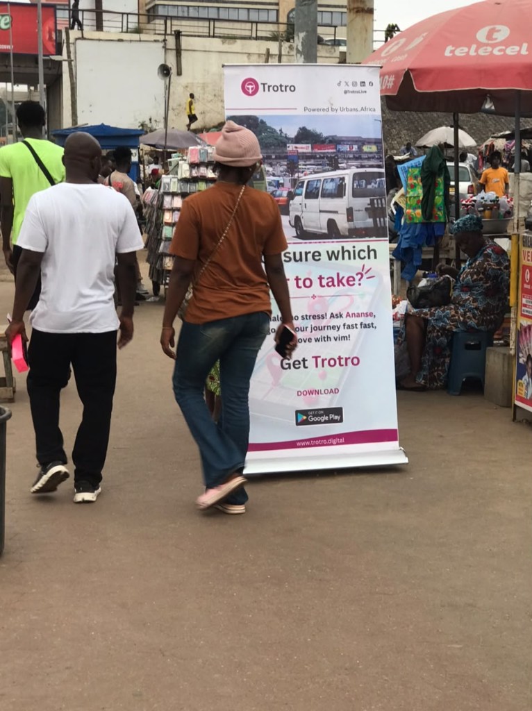 Commuters walking past the Trotro banner at a station